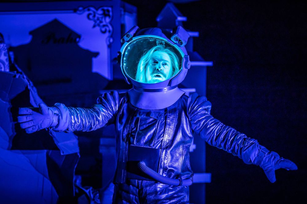 Mężczyzna ma na sobie strój kosmonauty, jego twarz wyraża dezorientację. Jest podświetlona na chłodny, niebieski kolor. - grafika artykułu
