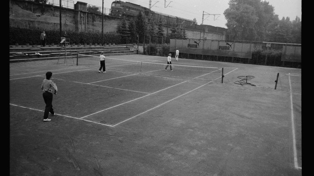 Ludzie grający na korcie w tenisa. Zdjęcie czarno-białe.